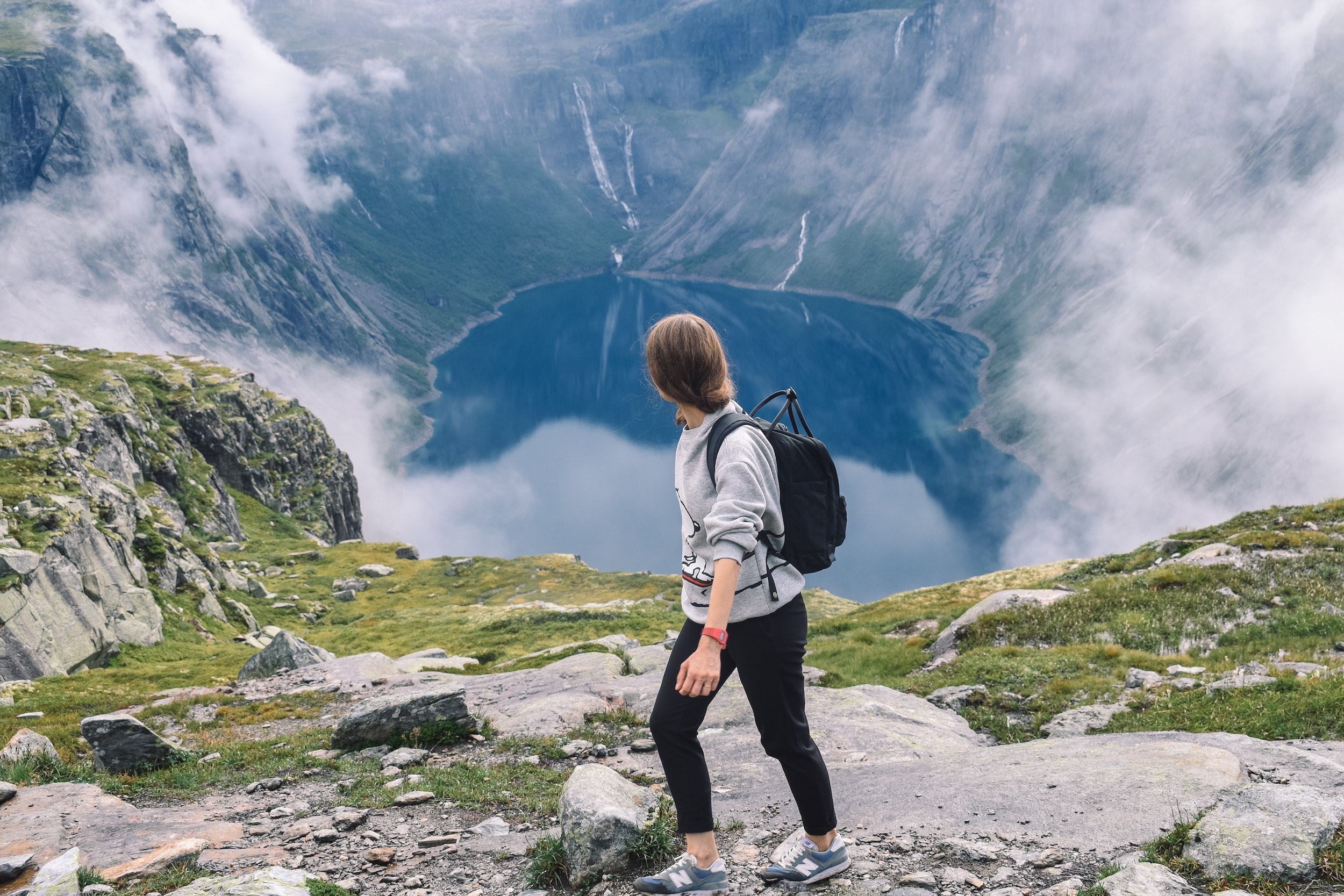 Hiker overlooking a stunning lake and mountainous landscape in Norway, highlighting the natural beauty and connectivity supported by NORDUnet and Norway's NREN - Sikt.