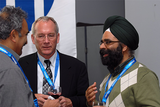 Images of three men having a conversation. They are all wearing a NORDUnet conference lanyard